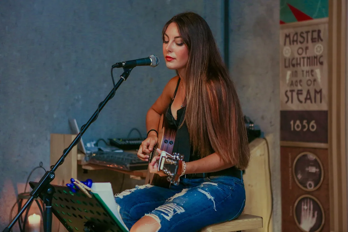 Persona tocando una guitarra acústica sentada