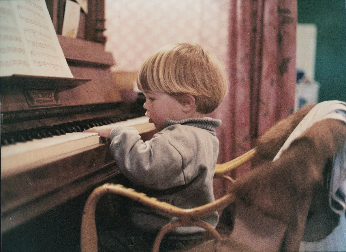 Niño pequeño tocando un piano en casa