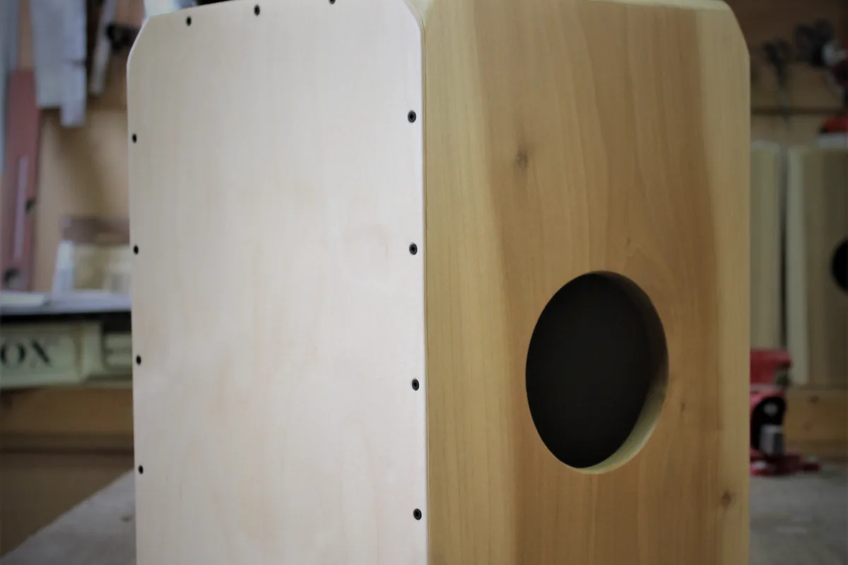 Primer plano de un cajón de madera clara con la boca redonda de la cara trasera, en un taller